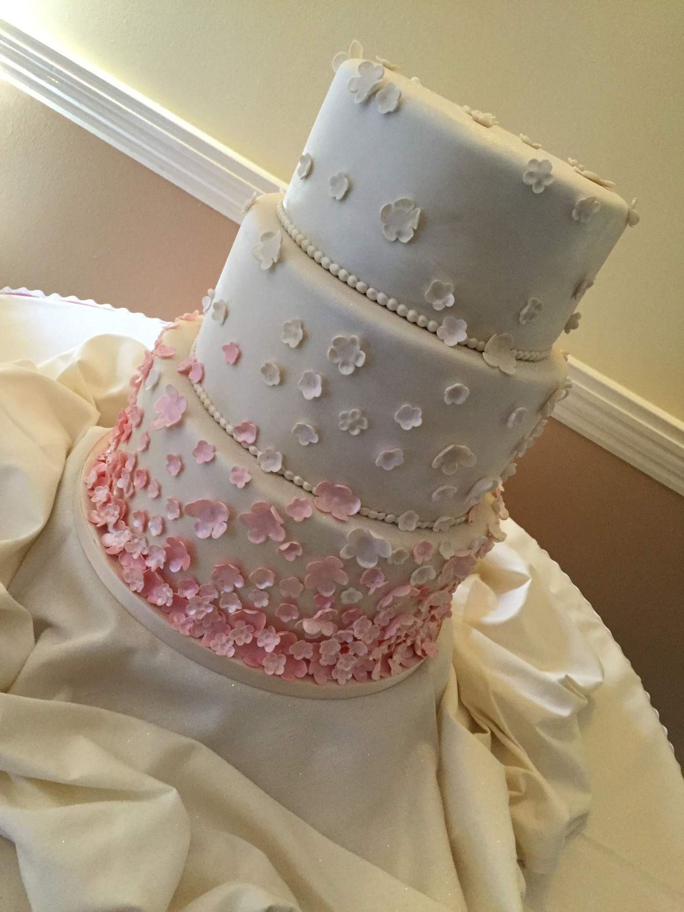 A tiered wedding cake with pink sugar flowers by North’s