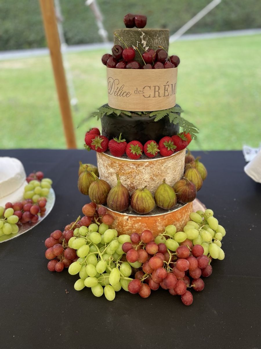 A cheese tower decorated with fruit and flowers