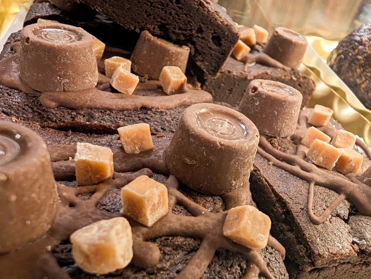 Close-up of chocolate brownies topped with fudge and caramel